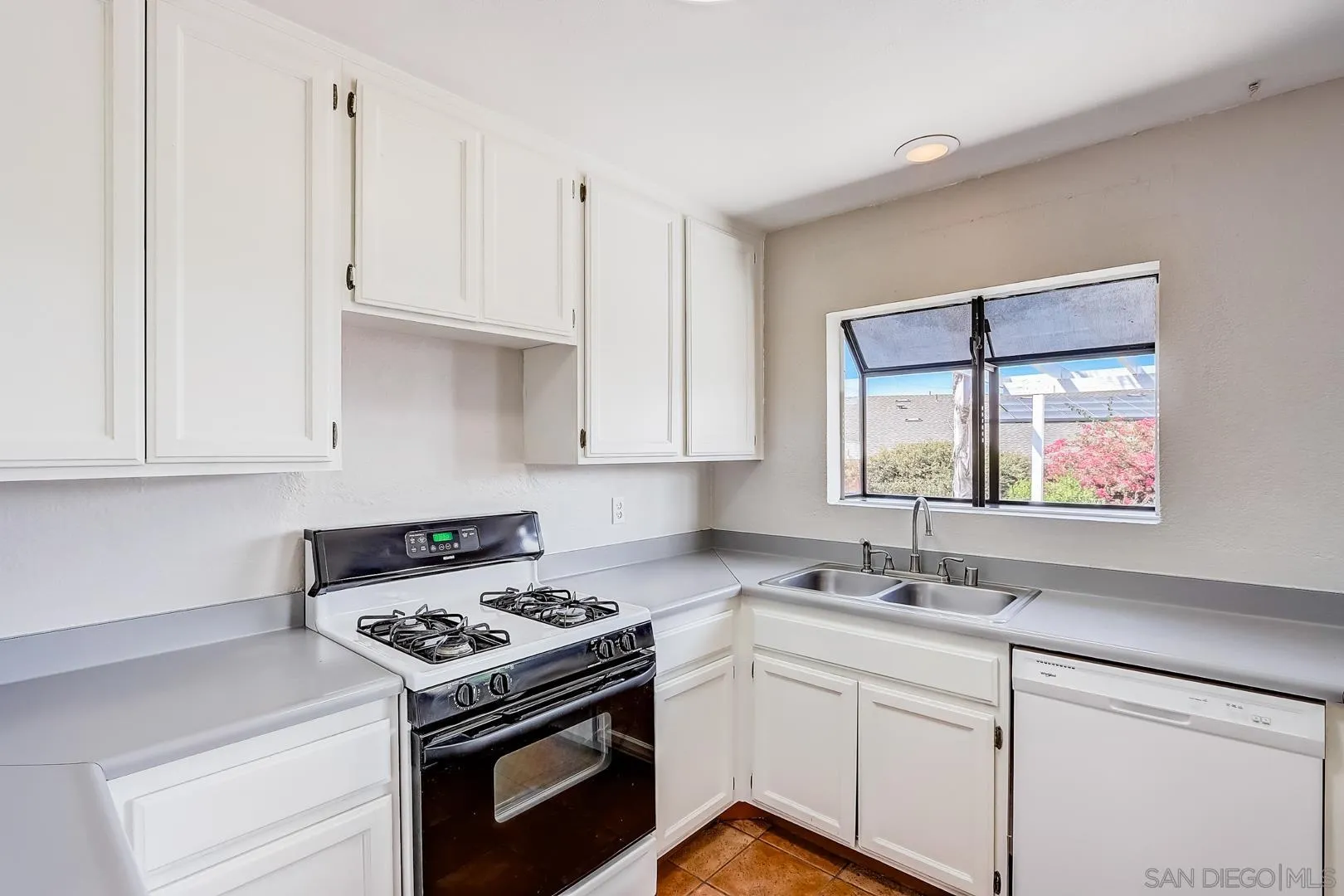 11988 Mountainview Heights Lakeside, CA 92040 - Photo 19 of 26 a kitchen with cabinets appliances a sink and a window