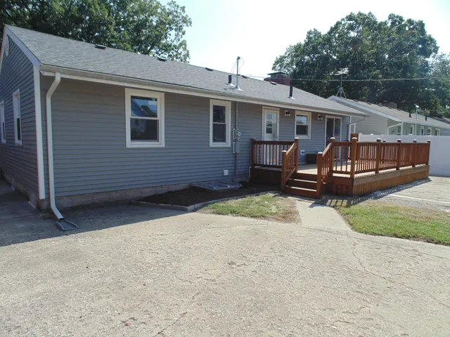 a view of a house with a yard and wooden fence