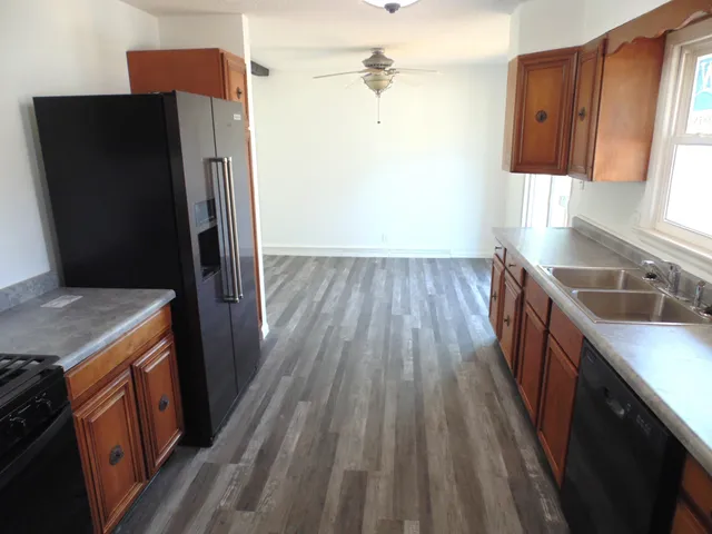 a kitchen with sink a refrigerator and wooden floor