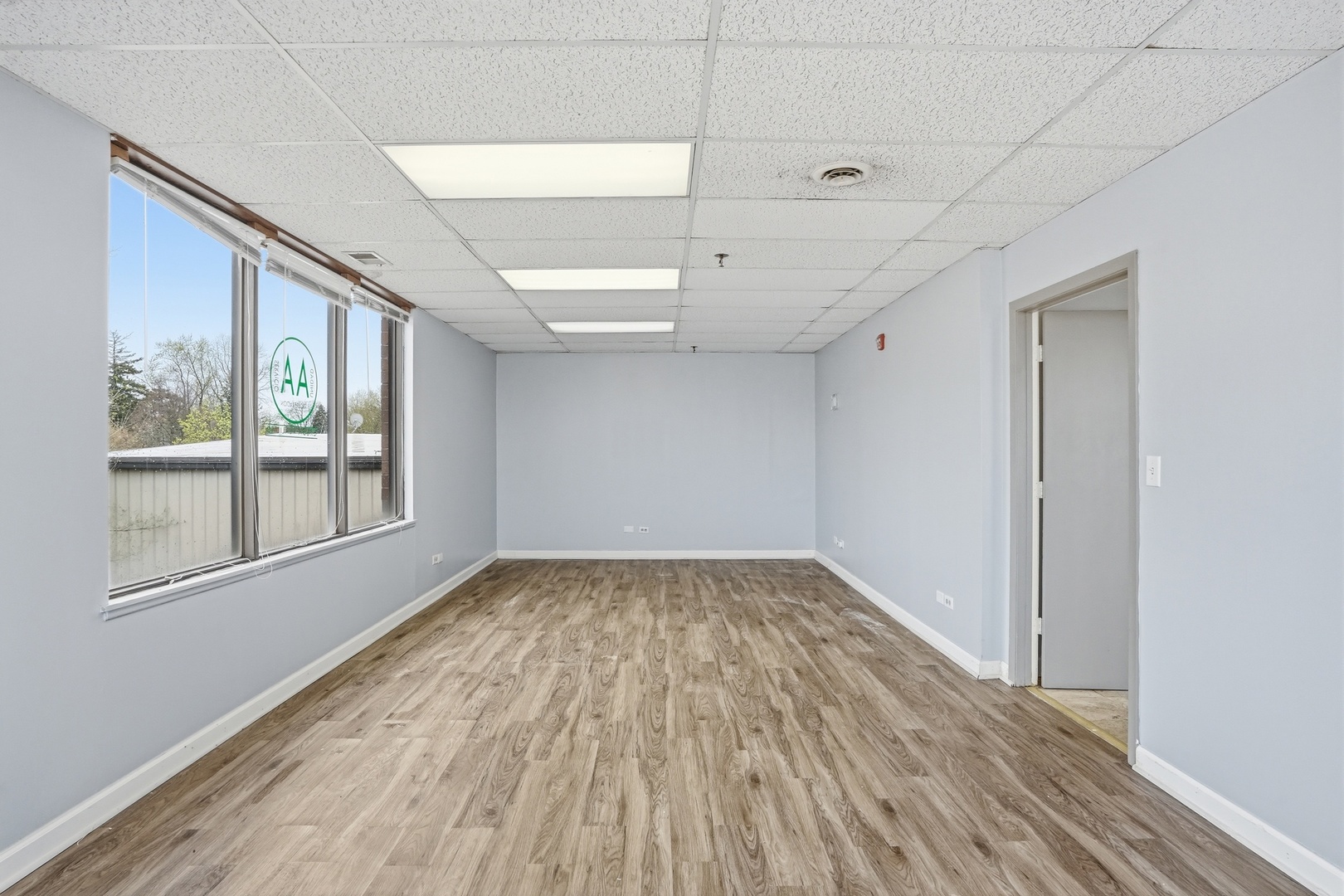 2071 Irving Park Road Hanover Park, IL 60133 - Photo 17 of 53 a view of an empty room with wooden floor and a window