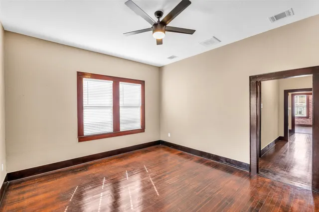 an empty room with a window and a ceiling fan