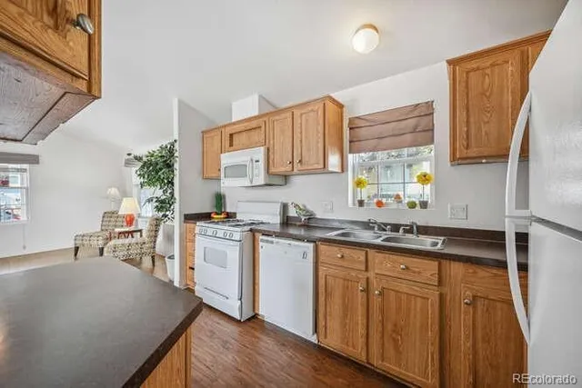 a kitchen with granite countertop a sink stove and cabinets