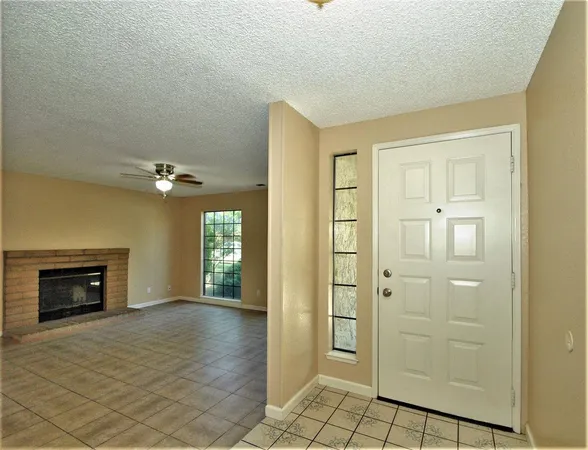 an empty room with windows and a fireplace