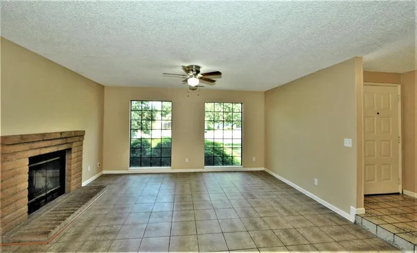 a view of an empty room with a fireplace and a window