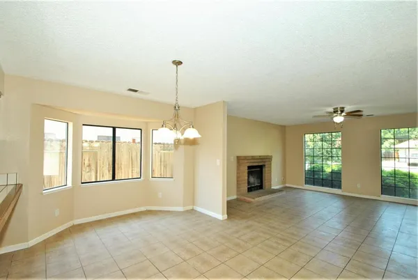a view of an empty room with a fireplace and a window