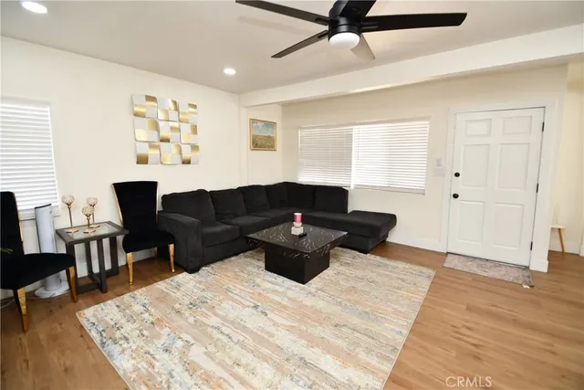 a living room with furniture and a wooden floor