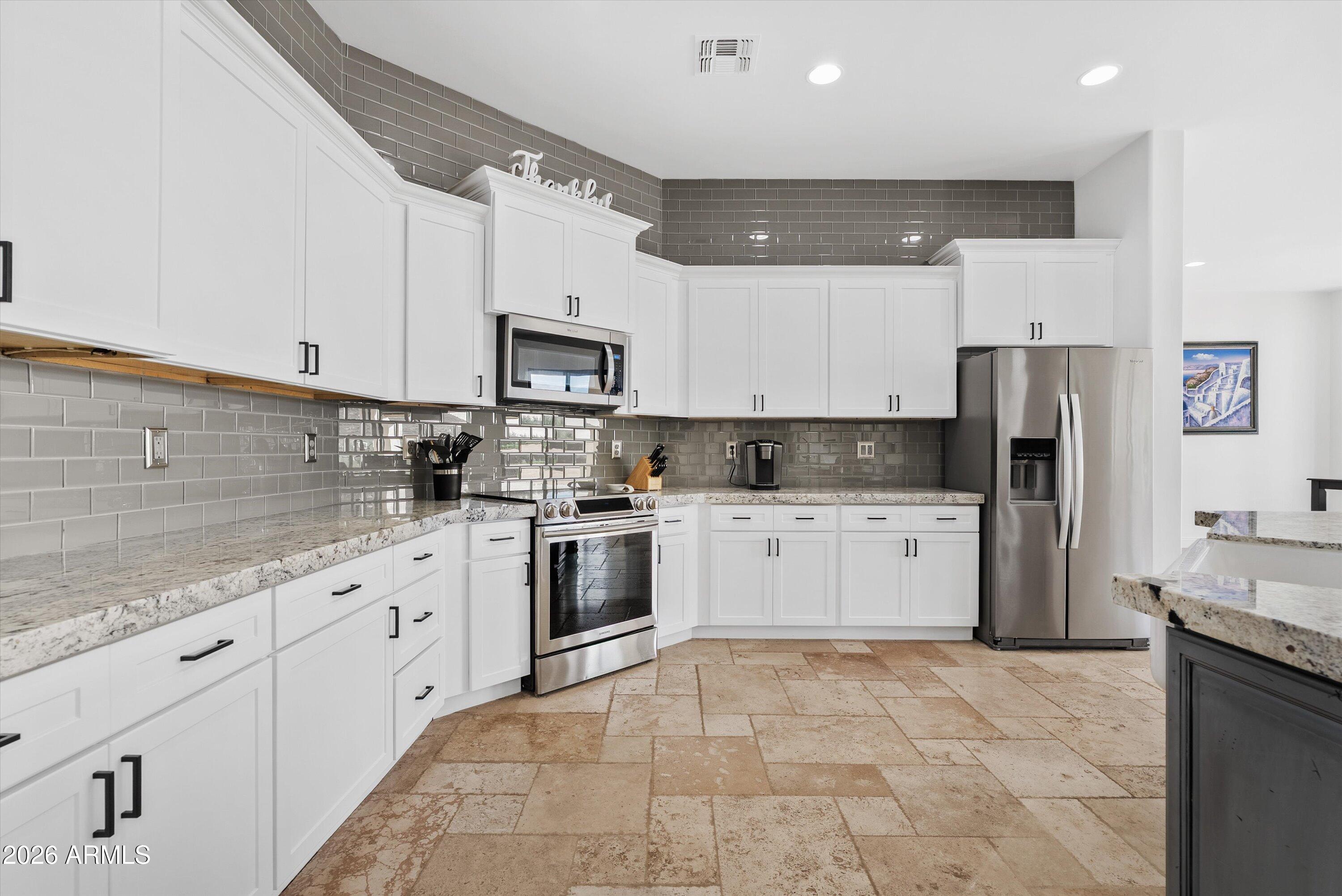 1617 West Maddock Road Phoenix, AZ 85086 - Photo 12 of 50 a kitchen with kitchen island granite countertop a stove a sink and a refrigerator