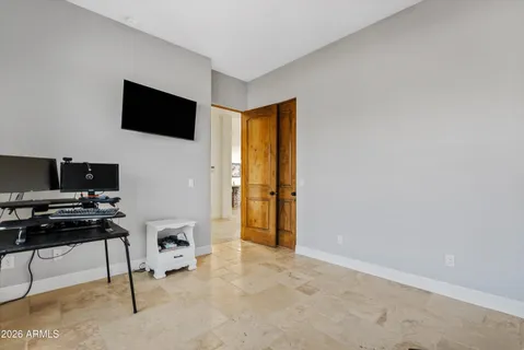a livingroom with workspace and a flat screen tv
