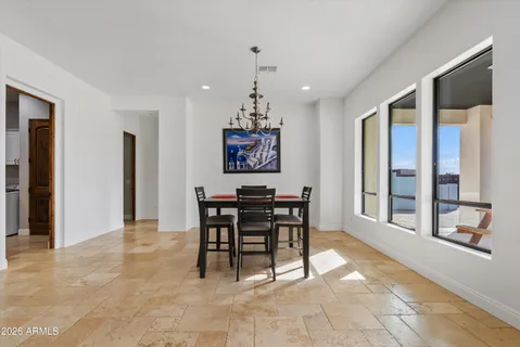 a dining room with chandelier and wooden floor