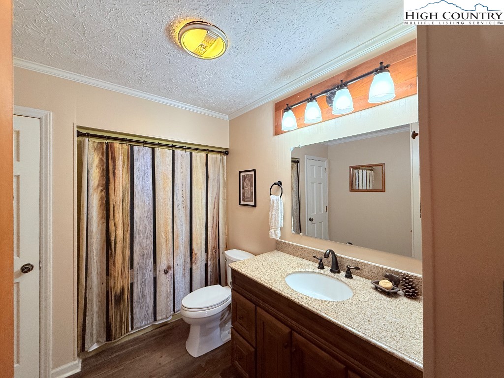 154 Breezy Lane Deep Gap, NC 28618 - Photo 13 of 46 a bathroom with a granite countertop sink toilet and a mirror