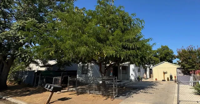a front view of a house with a tree