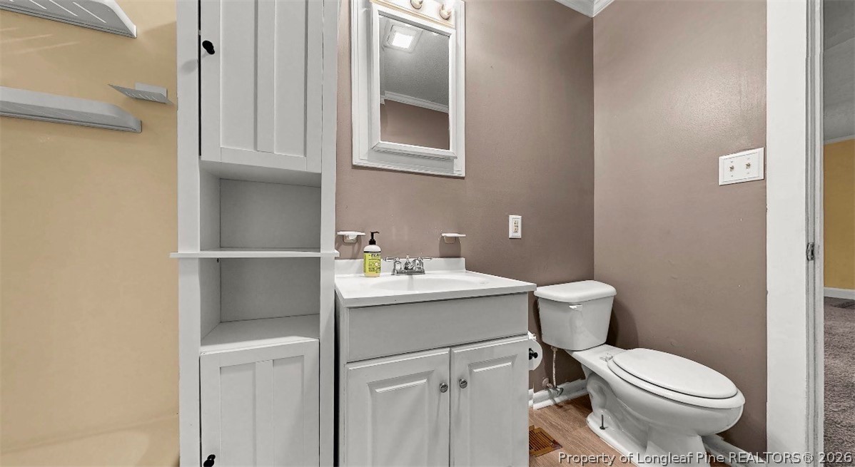 106 County Avenue Dunn, NC 28334 - Photo 22 of 24 a bathroom with a sink toilet and a mirror