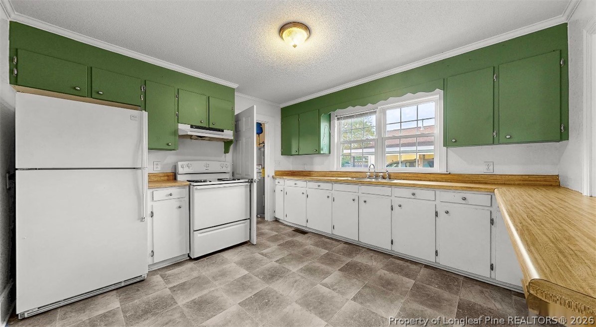 106 County Avenue Dunn, NC 28334 - Photo 6 of 24 a kitchen with white cabinets and white appliances