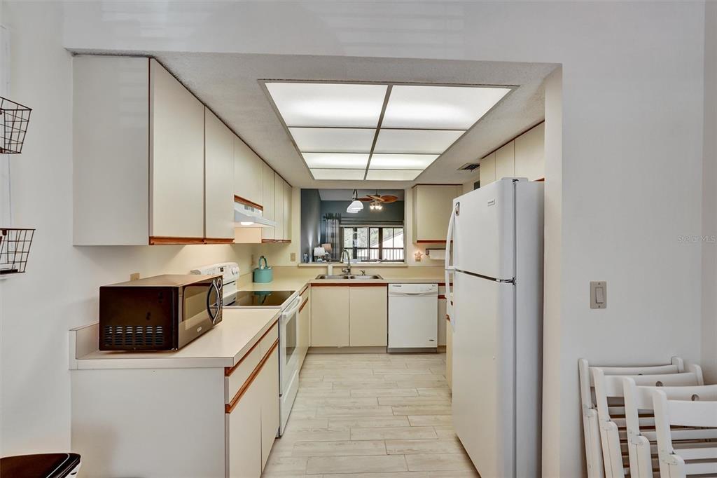 6221 Timberlake Drive, Unit C10 Sarasota, FL 34243 - Photo 12 of 27 a kitchen with a refrigerator a stove top oven a sink and dishwasher