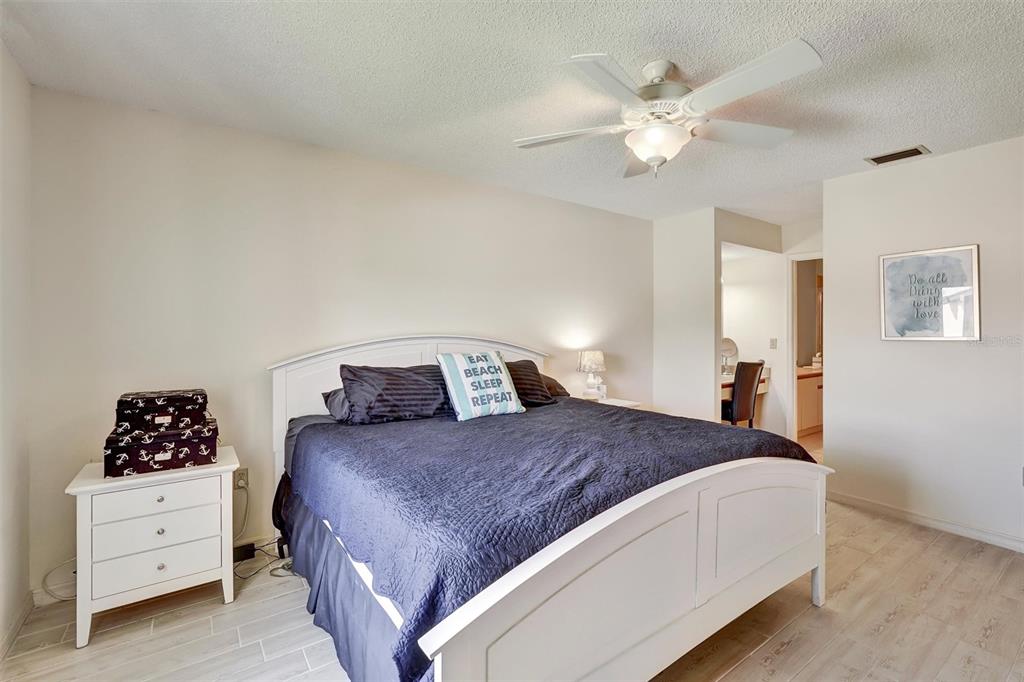 6221 Timberlake Drive, Unit C10 Sarasota, FL 34243 - Photo 15 of 27 a bedroom with a bed and a chandelier