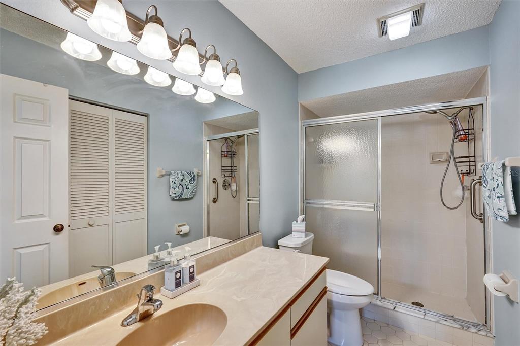 6221 Timberlake Drive, Unit C10 Sarasota, FL 34243 - Photo 18 of 27 a bathroom with a granite countertop sink a toilet and shower