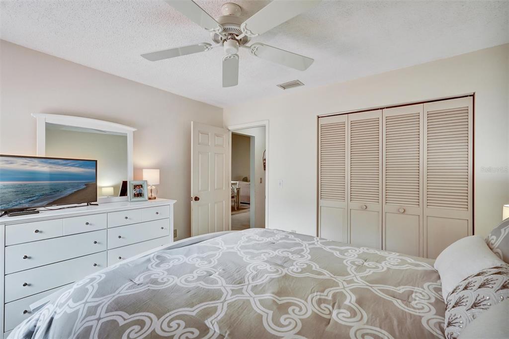 6221 Timberlake Drive, Unit C10 Sarasota, FL 34243 - Photo 21 of 27 a bedroom with a large bed and a flat tv screen on dresser