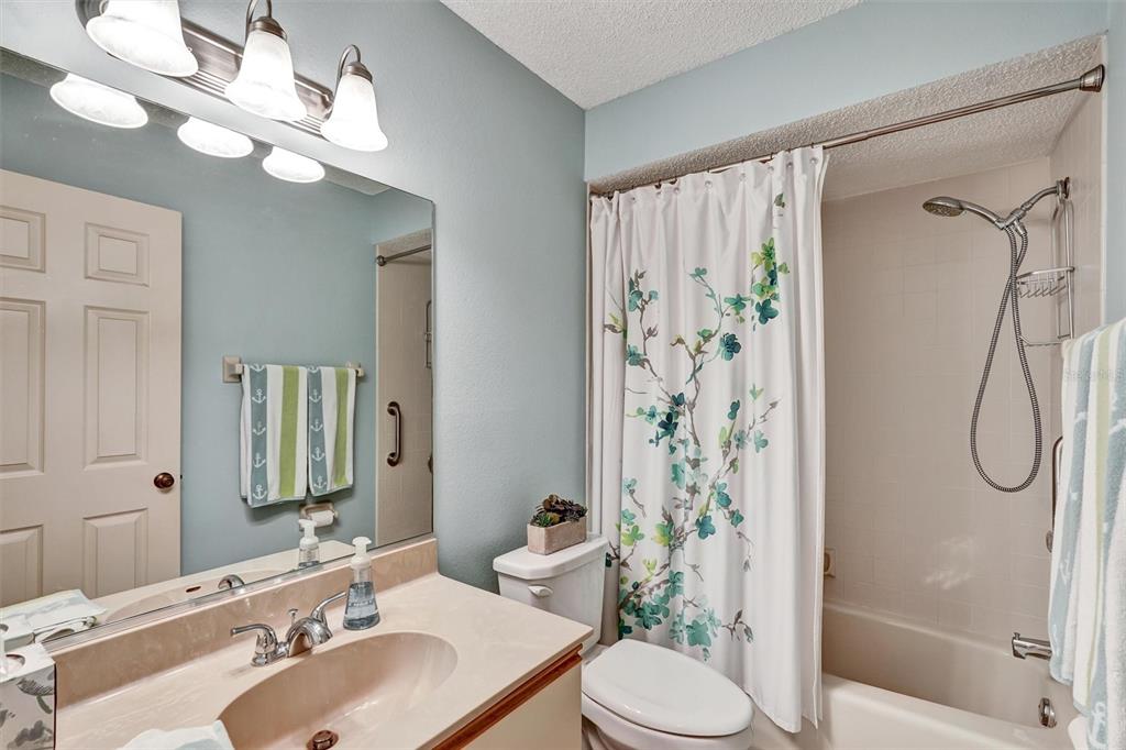 6221 Timberlake Drive, Unit C10 Sarasota, FL 34243 - Photo 23 of 27 a bathroom with a sink vanity mirror toilet and shower