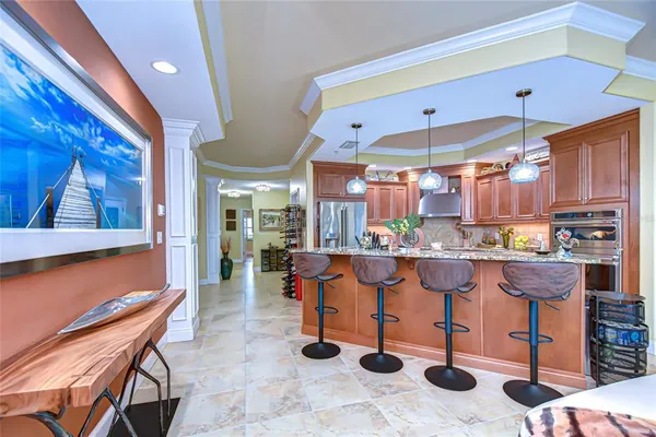 a open kitchen with stainless steel appliances kitchen island granite countertop a table and chairs in it