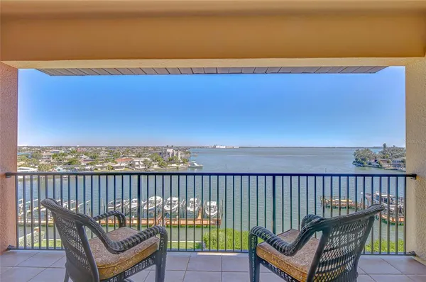 a view of a balcony with wooden chairs