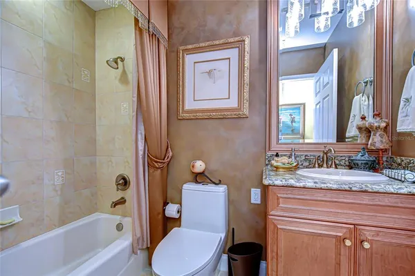 a bathroom with a granite countertop toilet sink and mirror