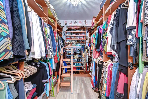 a view of walk in closet with clothes