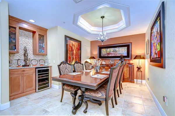 a view of a dining room with furniture a chandelier and a flat screen tv
