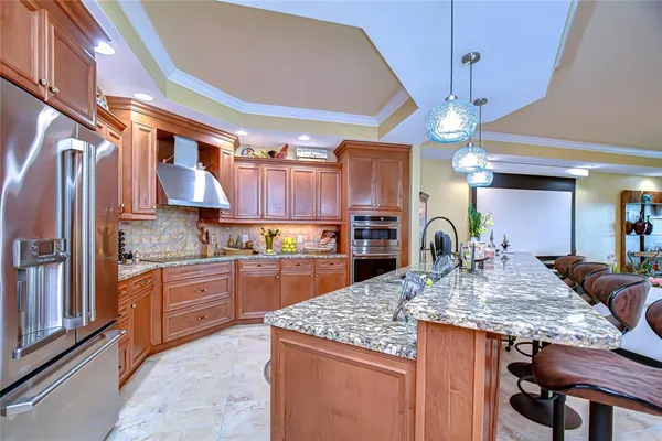 a kitchen with kitchen island granite countertop a table chairs stainless steel appliances and cabinets