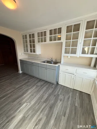 a living room with wooden floors and cabinet