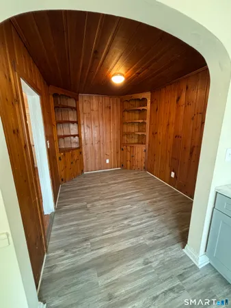 a view of an empty room with wooden floor and stairs