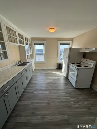 a view of a kitchen with wooden floor and electronic appliances