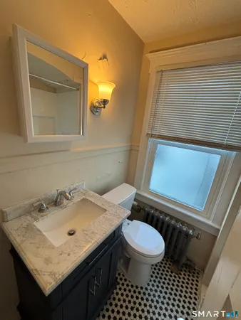 a bathroom with a sink a toilet and a mirror