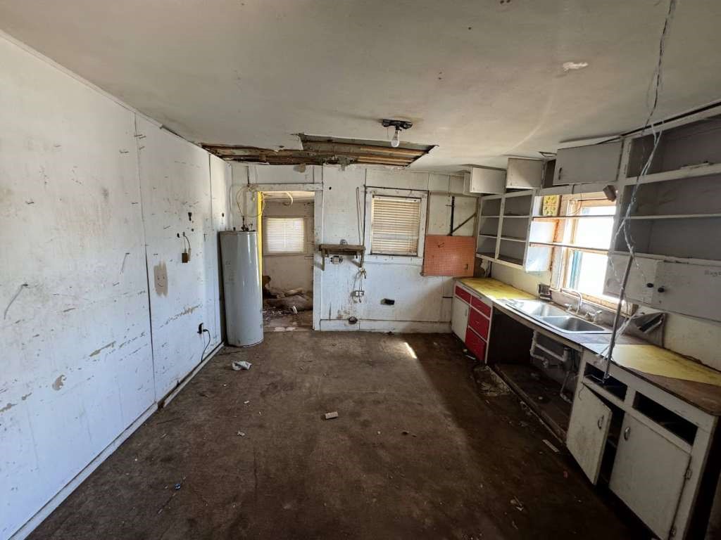 650 South 6th Street Slaton, TX 79364 - Photo 8 of 9 a kitchen with stainless steel appliances a stove refrigerator and cabinets