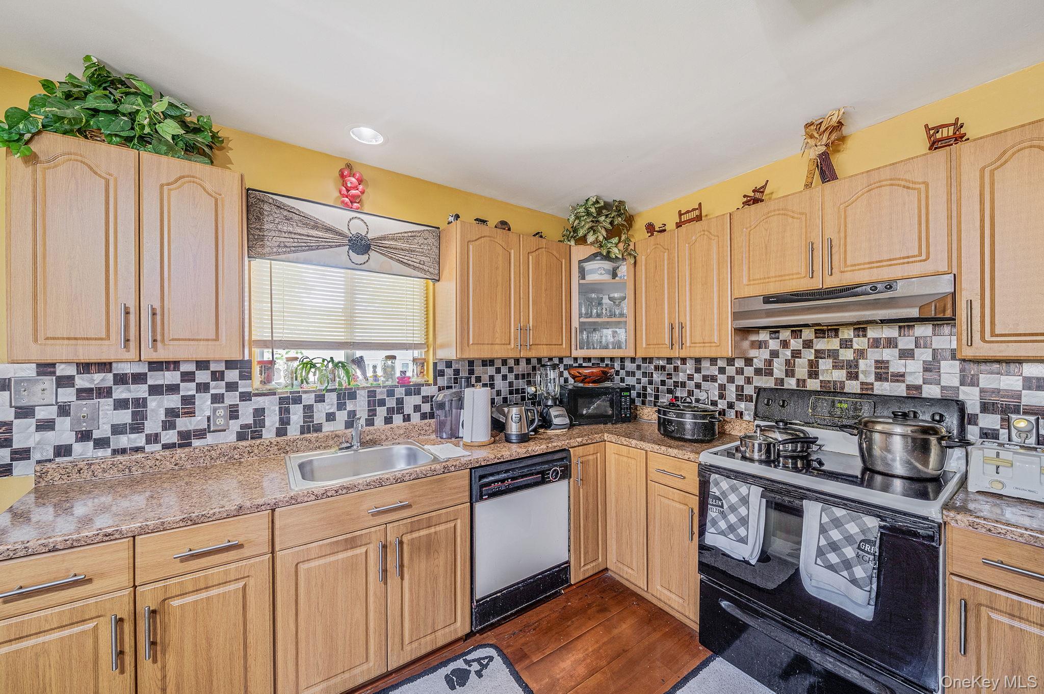 1169 Little E Neck Road West Babylon, NY 11704 - Photo 10 of 28 a kitchen with a sink stove and cabinets