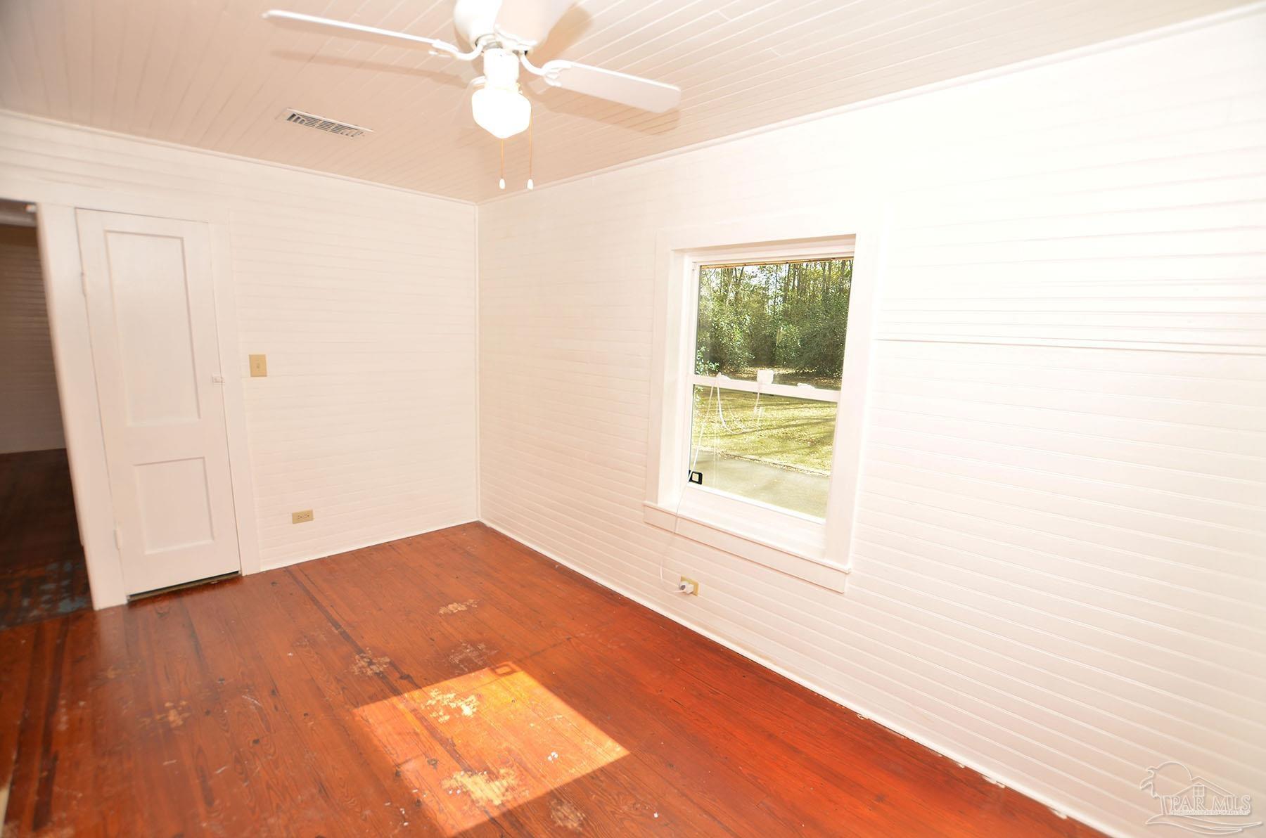 6475 Chestnut Road Molino, FL 32577 - Photo 27 of 67 a view of an empty room with wooden floor and a window