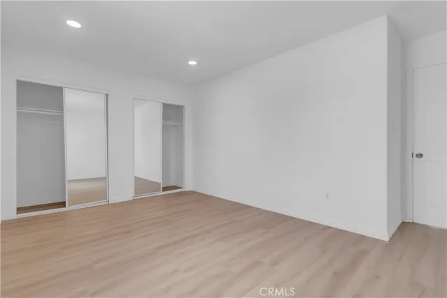 an empty room with kitchen and natural light