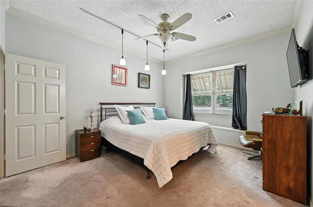 a spacious bedroom with a bed and a flat screen tv