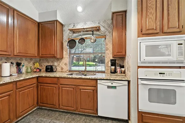 a kitchen with stainless steel appliances granite countertop a sink and cabinets with wooden floor