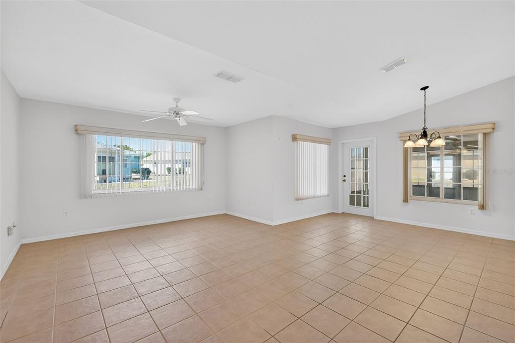 8739 Southeast 140th Place Road Summerfield, FL 34491 - Photo 12 of 45 an empty room with windows and chandelier fan