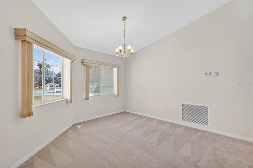 8739 Southeast 140th Place Road Summerfield, FL 34491 - Photo 21 of 45 an empty room with windows and chandelier