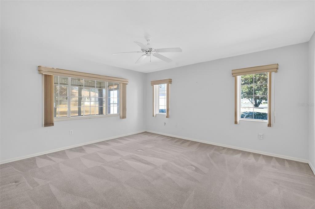 8739 Southeast 140th Place Road Summerfield, FL 34491 - Photo 23 of 45 an empty room with windows and ceiling fan view