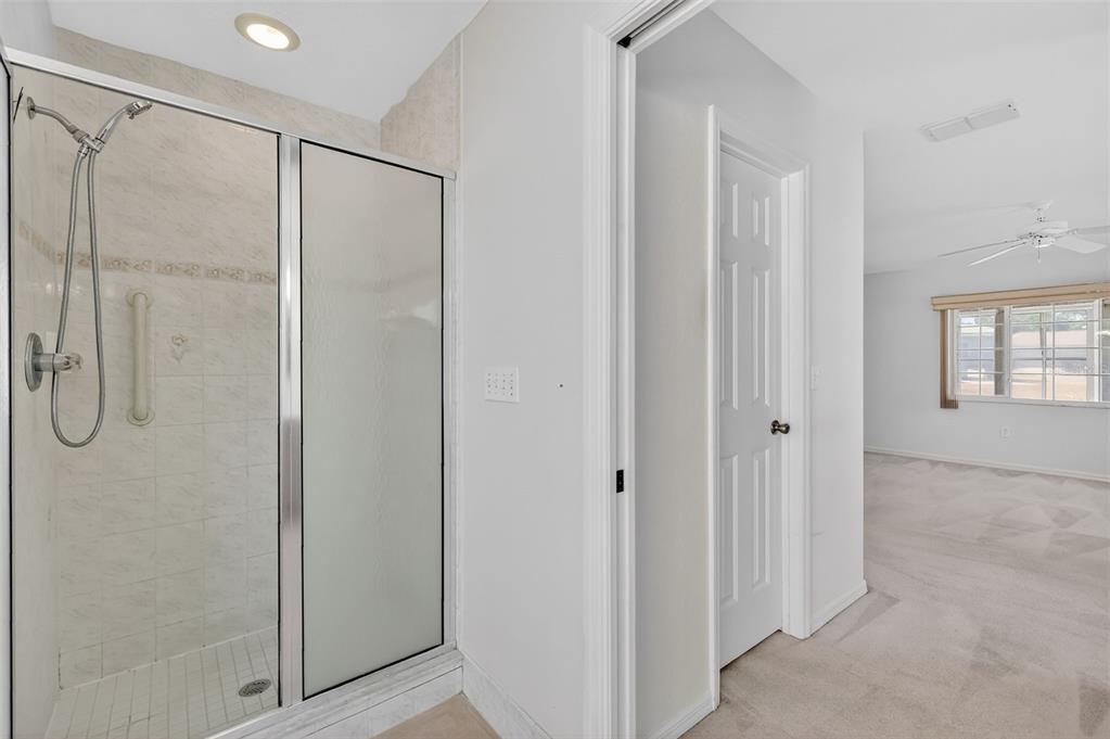 8739 Southeast 140th Place Road Summerfield, FL 34491 - Photo 28 of 45 a bathroom with a glass shower door