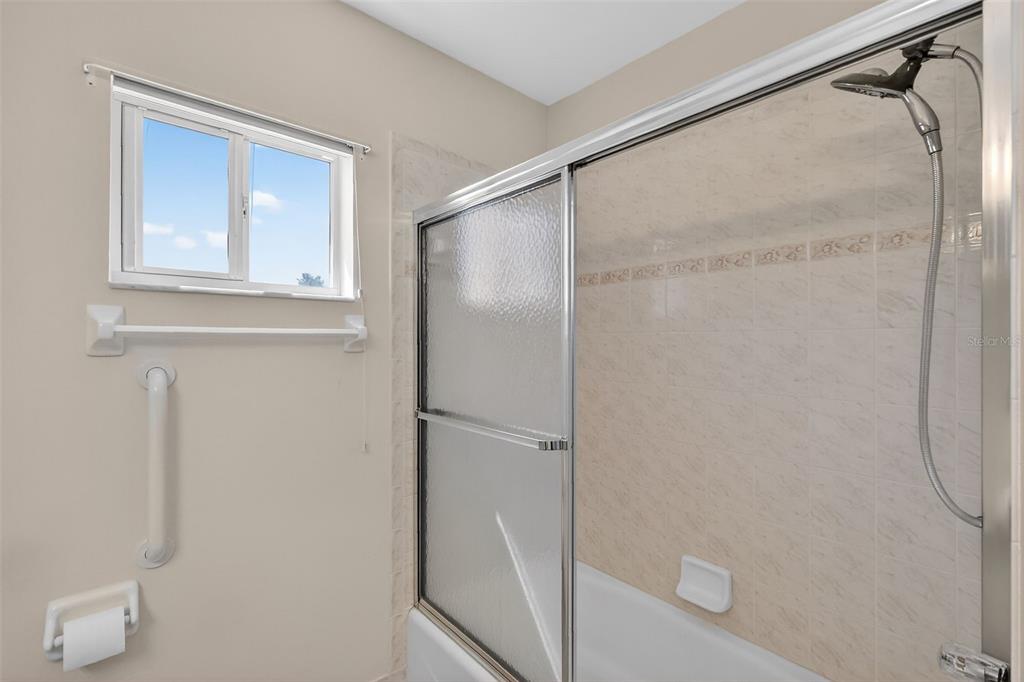 8739 Southeast 140th Place Road Summerfield, FL 34491 - Photo 33 of 45 a bathroom with a glass shower door