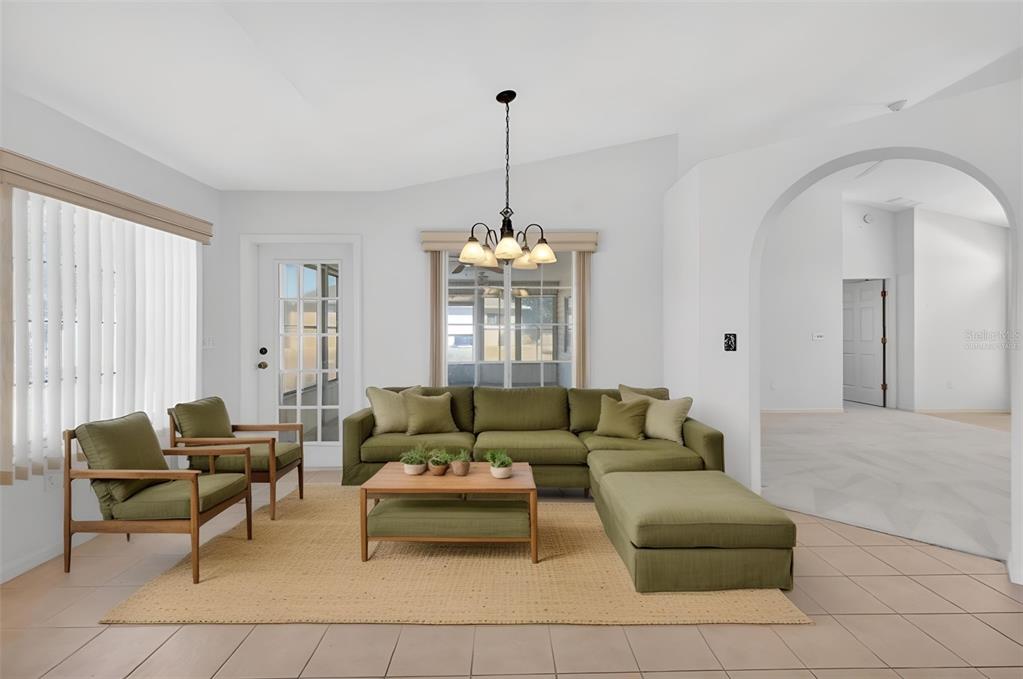 8739 Southeast 140th Place Road Summerfield, FL 34491 - Photo 9 of 45 a living room with furniture and a chandelier