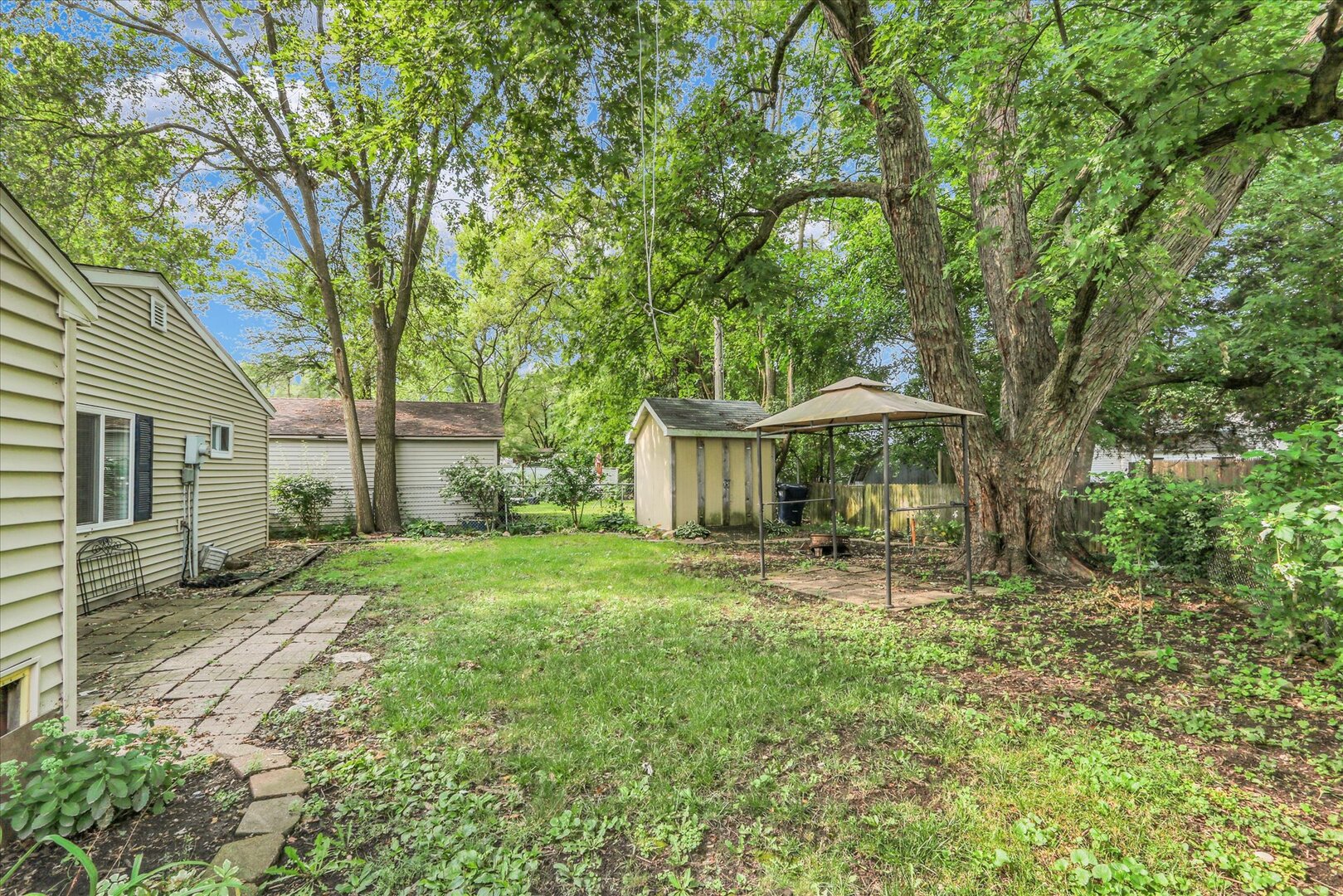 817 Roselyn Drive Rantoul, IL 61866 - Photo 29 of 33 a backyard of a house with table and chairs under an umbrella