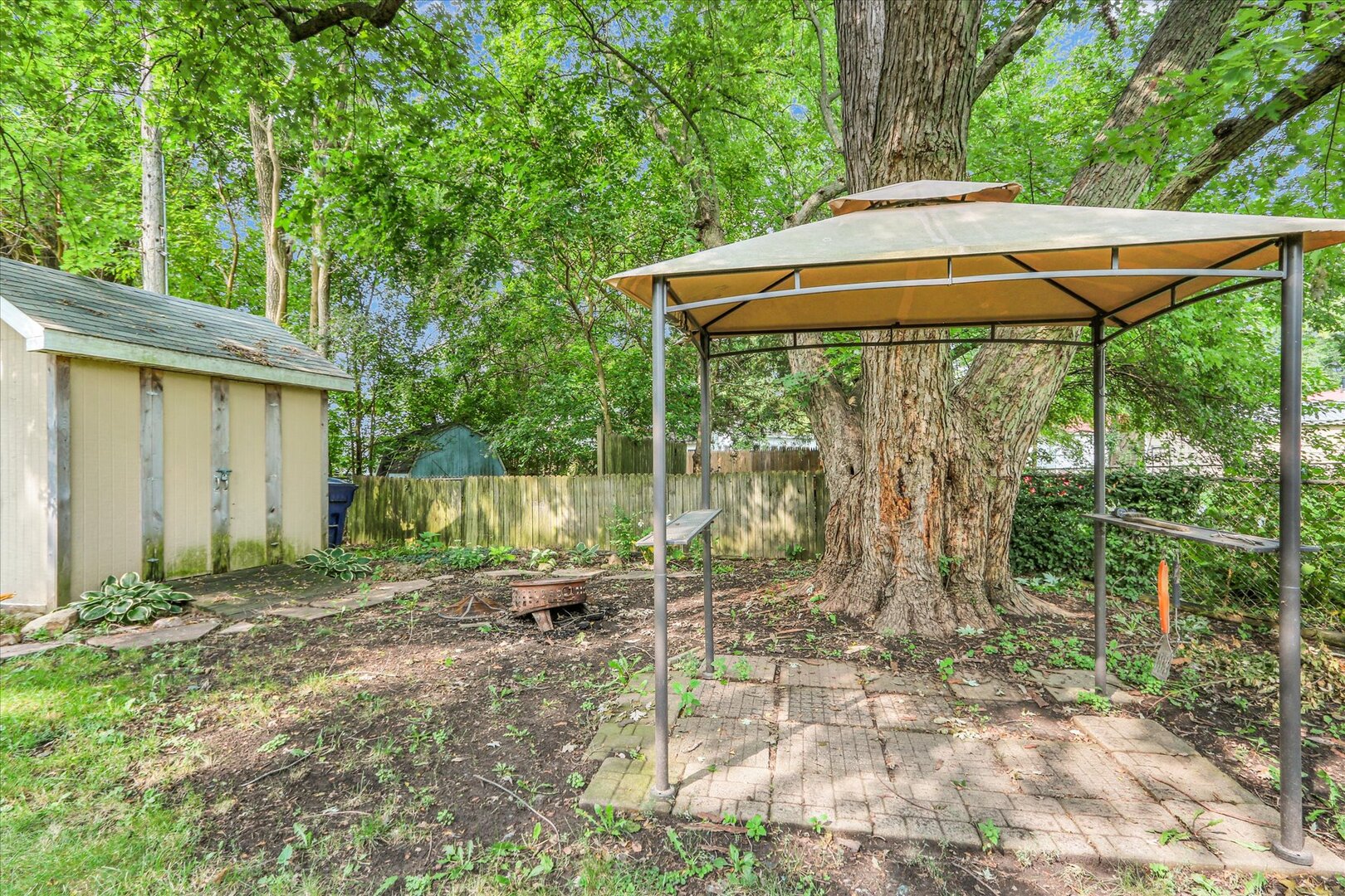 817 Roselyn Drive Rantoul, IL 61866 - Photo 31 of 33 a backyard of a house with table and chairs under an umbrella