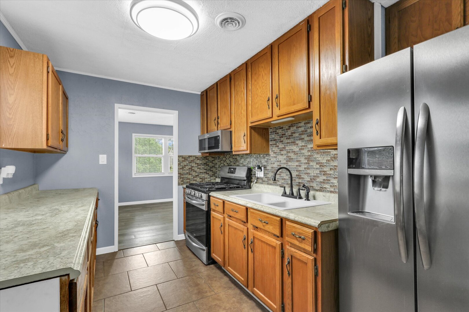 817 Roselyn Drive Rantoul, IL 61866 - Photo 9 of 33 a kitchen with stainless steel appliances granite countertop a sink stove refrigerator and cabinets