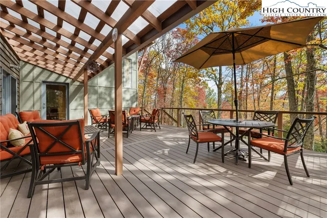 a view of a roof deck with table and chairs under an umbrella with wooden floor