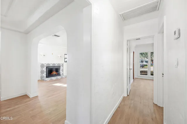 a view of a hallway with wooden floor and a fireplace