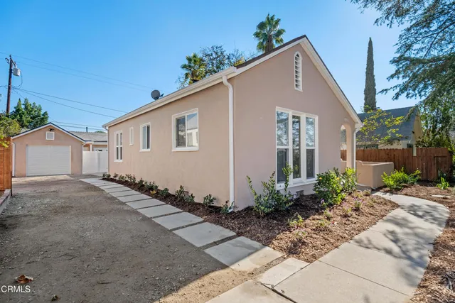 a front view of house with yard and trees around